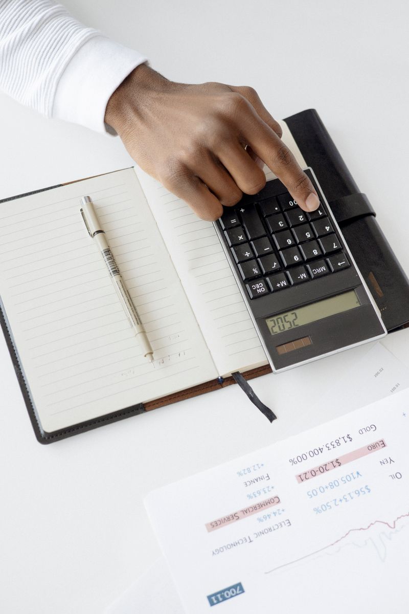 A smartphone showing the SplitWise Canada group expense list with balances for each member